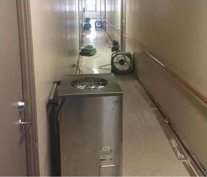Our air movers set up in a business hallway after water damage soaked the floors