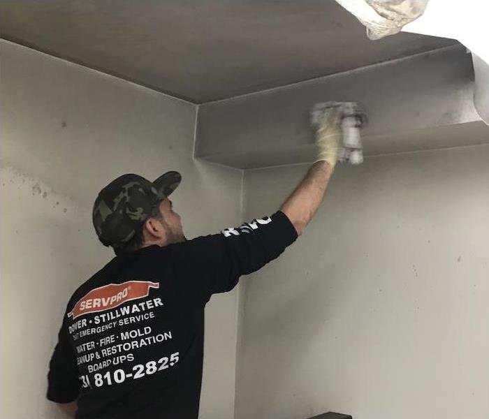 Employee removing soot damage from a wall