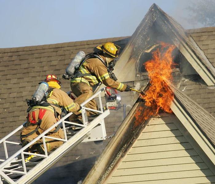 Firefighters putting a fire out in a window.